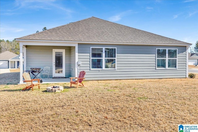 rear view of house featuring a yard and an outdoor fire pit