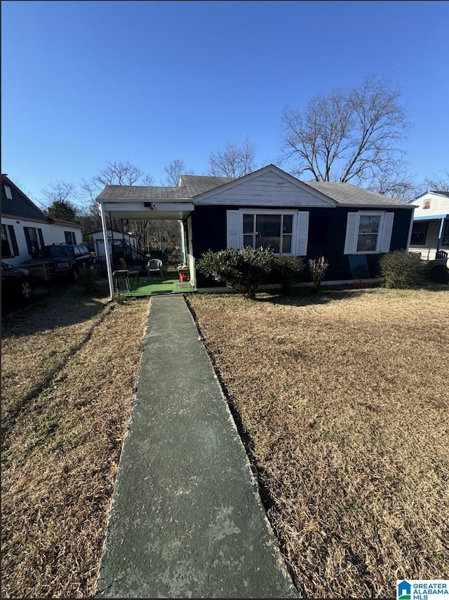 view of front of home with a front lawn and a carport