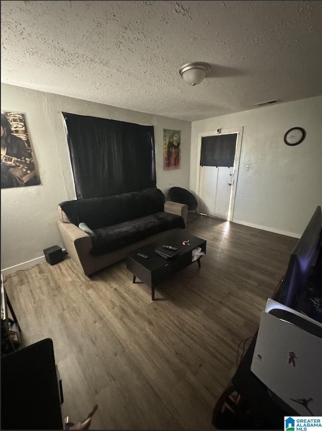 living room featuring dark hardwood / wood-style floors and a textured ceiling