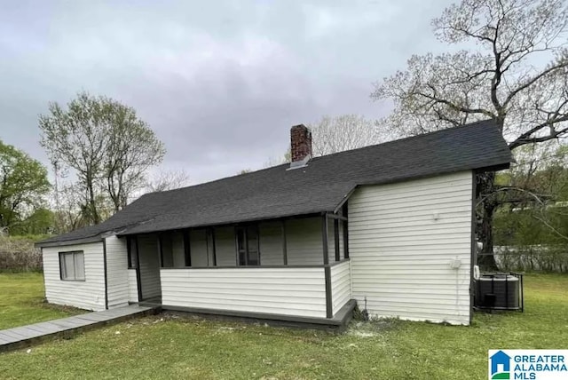 rear view of property with a yard and central AC unit