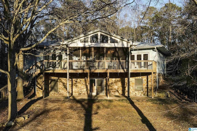 rear view of house featuring a wooden deck, a patio area, and a sunroom