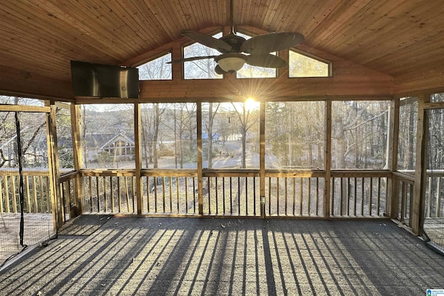 unfurnished sunroom with vaulted ceiling, wooden ceiling, ceiling fan, and plenty of natural light