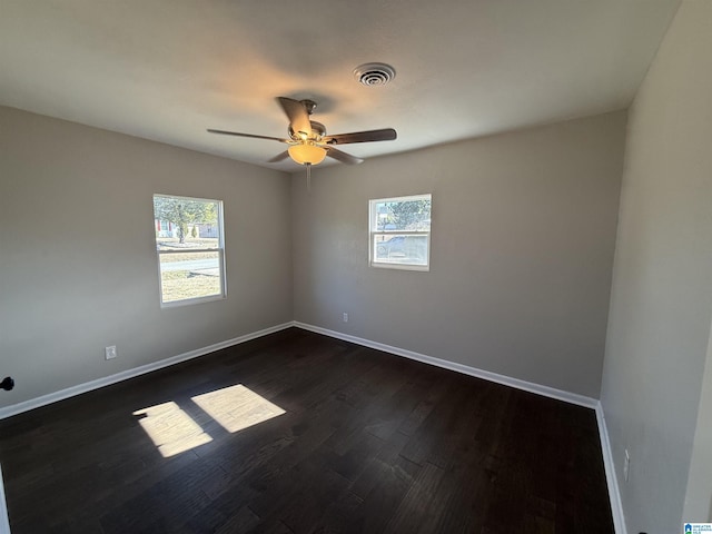 spare room with ceiling fan, dark hardwood / wood-style floors, and a wealth of natural light