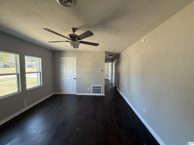 unfurnished bedroom featuring dark wood-type flooring, a textured ceiling, and ceiling fan