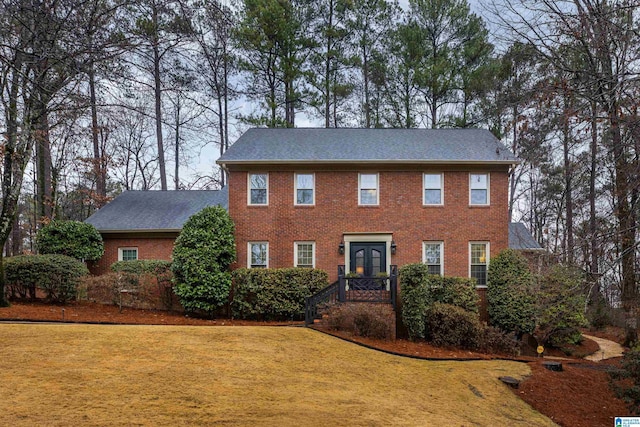 colonial inspired home with a front yard and french doors