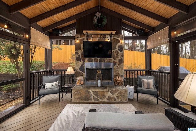 sunroom / solarium with wooden ceiling, an outdoor stone fireplace, and vaulted ceiling with beams