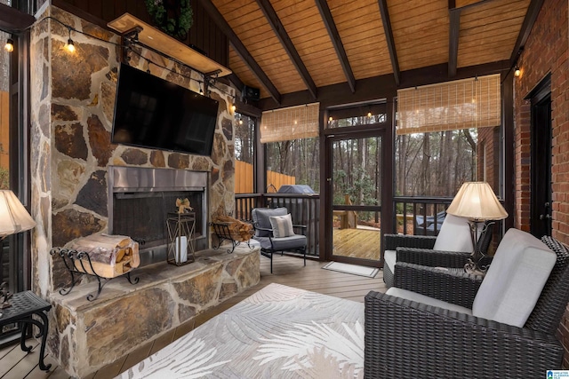 sunroom featuring vaulted ceiling with beams, wood ceiling, and an outdoor stone fireplace