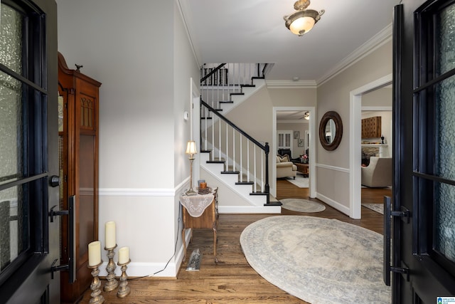 entrance foyer featuring ornamental molding and dark hardwood / wood-style floors