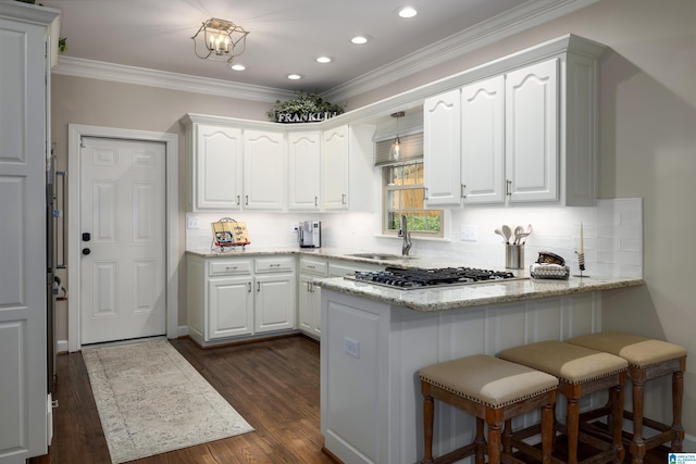 kitchen featuring white cabinetry, sink, light stone countertops, and stainless steel gas cooktop