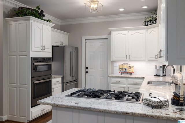 kitchen featuring sink, crown molding, stainless steel appliances, light stone counters, and white cabinets