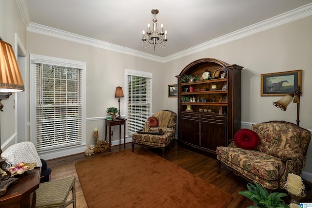 sitting room featuring dark wood-type flooring, plenty of natural light, ornamental molding, and a chandelier