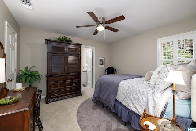 bedroom featuring connected bathroom, light carpet, and ceiling fan