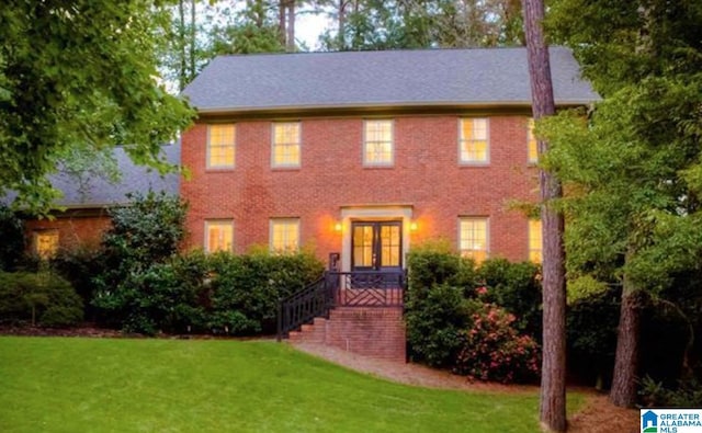 colonial inspired home featuring a front lawn