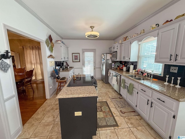 kitchen with white cabinetry, stainless steel appliances, crown molding, and sink