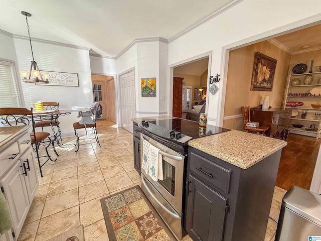 kitchen featuring stainless steel range with electric cooktop, ornamental molding, a kitchen island, a notable chandelier, and white cabinets