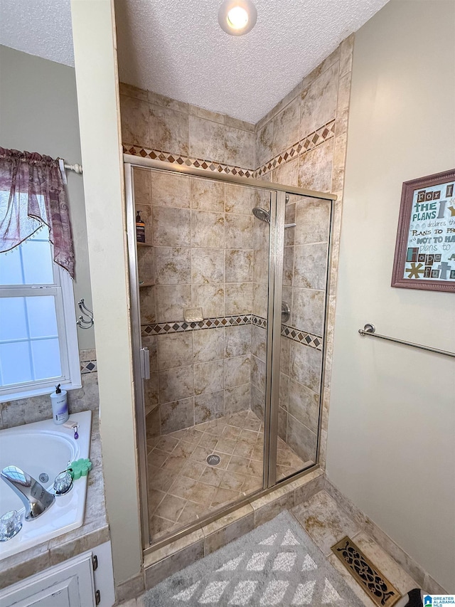 bathroom with independent shower and bath and a textured ceiling