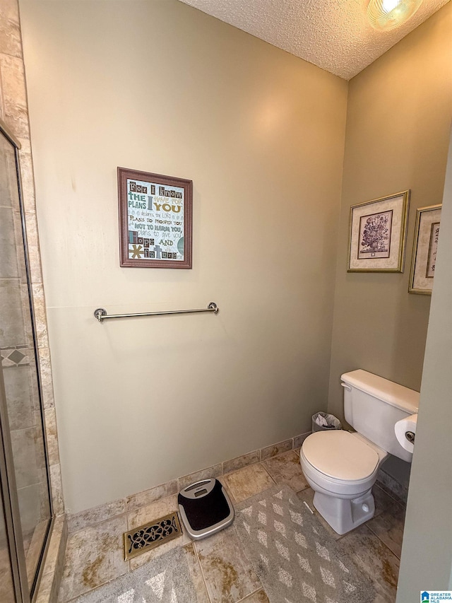 bathroom featuring a textured ceiling and toilet