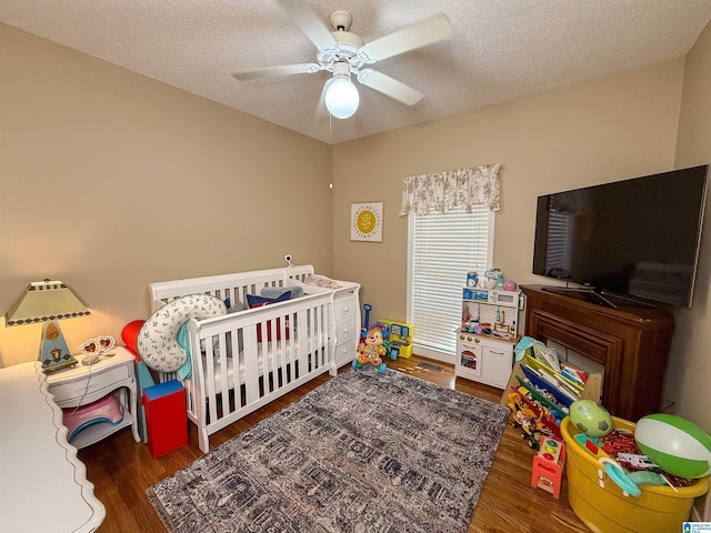 bedroom with ceiling fan, dark hardwood / wood-style flooring, and a textured ceiling