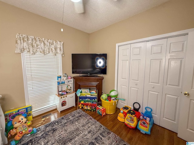 game room with dark hardwood / wood-style flooring, ceiling fan, and a textured ceiling