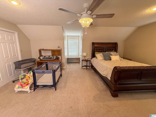 carpeted bedroom with vaulted ceiling, ceiling fan, and a textured ceiling