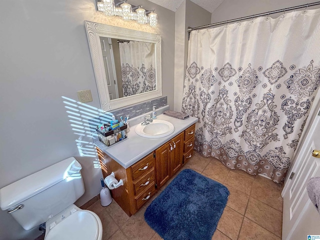 bathroom with tile patterned flooring, vaulted ceiling, vanity, and toilet