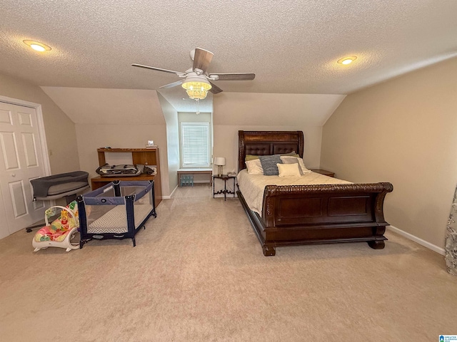 carpeted bedroom with ceiling fan, vaulted ceiling, and a textured ceiling