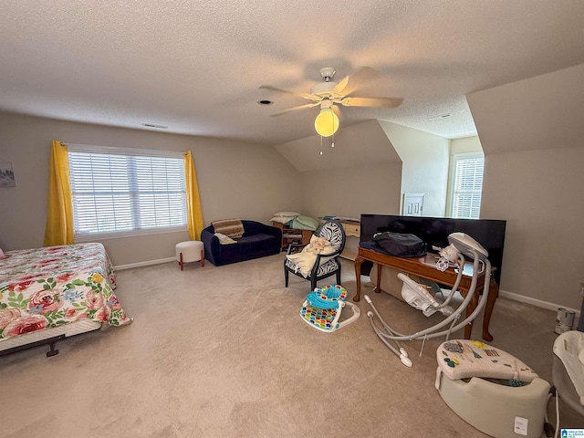 bedroom with vaulted ceiling, light colored carpet, ceiling fan, and a textured ceiling