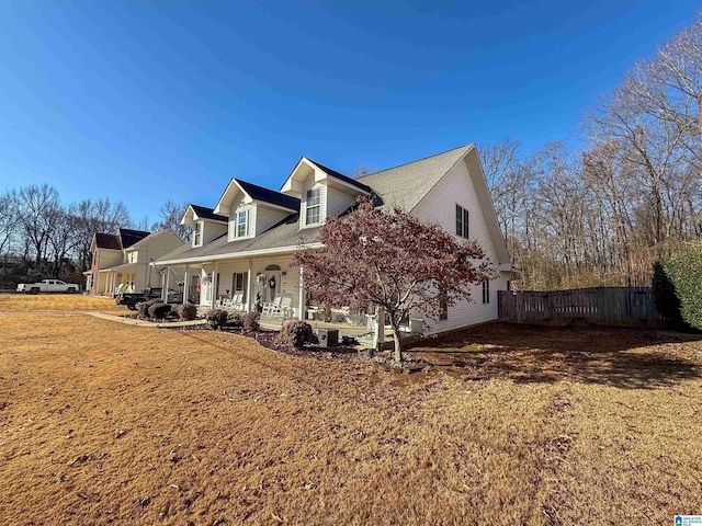 view of side of home with a lawn and covered porch