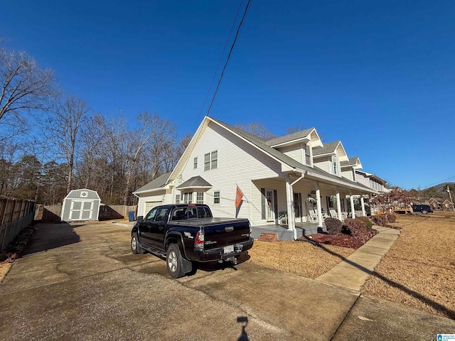 view of property exterior featuring a garage, a storage unit, and a porch