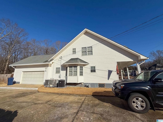 view of front of home with a garage and central air condition unit