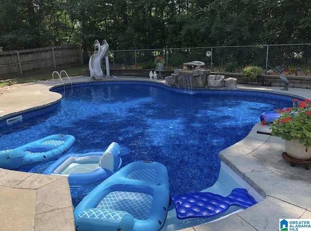 view of swimming pool with a water slide