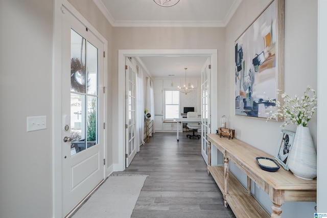 interior space featuring ornamental molding, wood-type flooring, and a notable chandelier