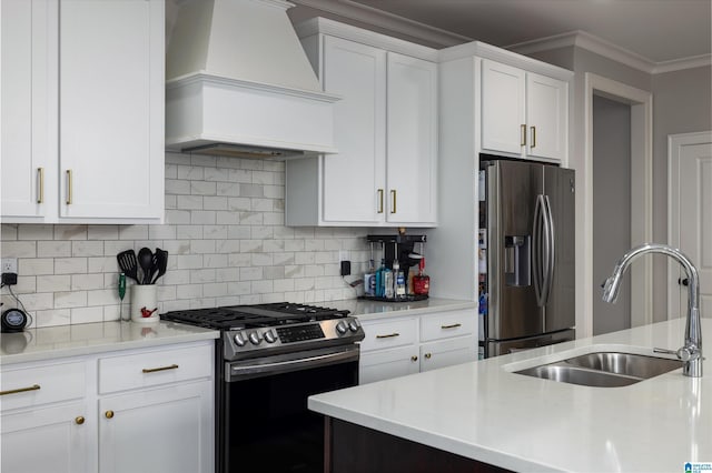 kitchen featuring stainless steel appliances, white cabinetry, custom range hood, and sink