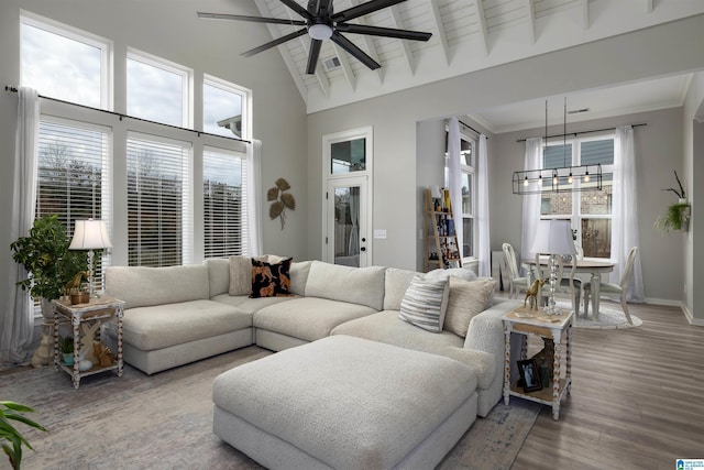 living room featuring hardwood / wood-style flooring, ceiling fan, beam ceiling, high vaulted ceiling, and ornamental molding