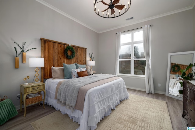 bedroom featuring ornamental molding and light wood-type flooring