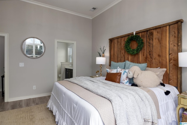 bedroom featuring hardwood / wood-style flooring, ensuite bath, and ornamental molding