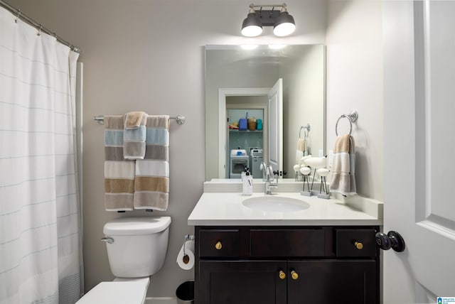 bathroom featuring separate washer and dryer, vanity, curtained shower, and toilet