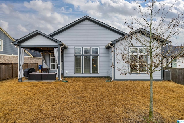 back of house featuring an outdoor living space, central AC unit, and a lawn