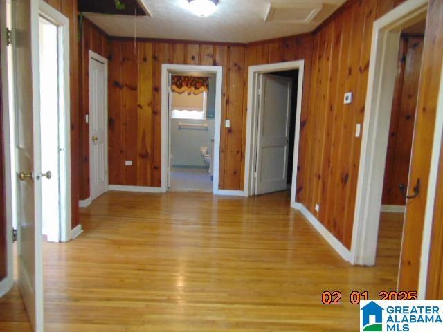 interior space with wooden walls and light hardwood / wood-style flooring