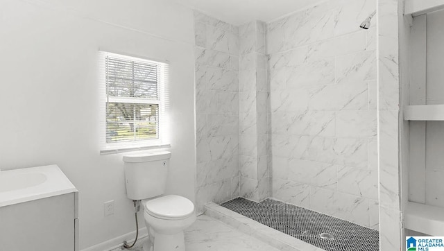 bathroom with vanity, a tile shower, and toilet