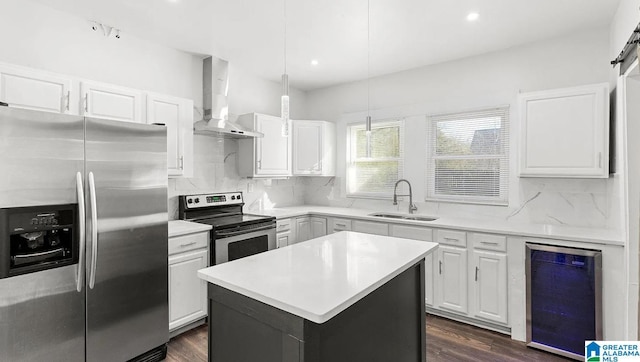 kitchen with white cabinets, beverage cooler, a center island, stainless steel appliances, and wall chimney exhaust hood