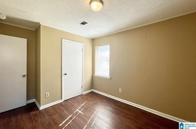 unfurnished bedroom featuring ornamental molding, dark hardwood / wood-style flooring, and a textured ceiling