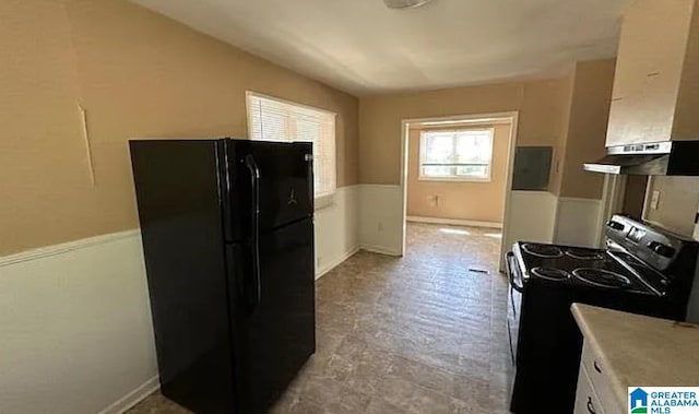 kitchen with white cabinetry, extractor fan, and black appliances