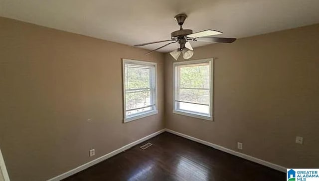 spare room with ceiling fan and dark hardwood / wood-style floors