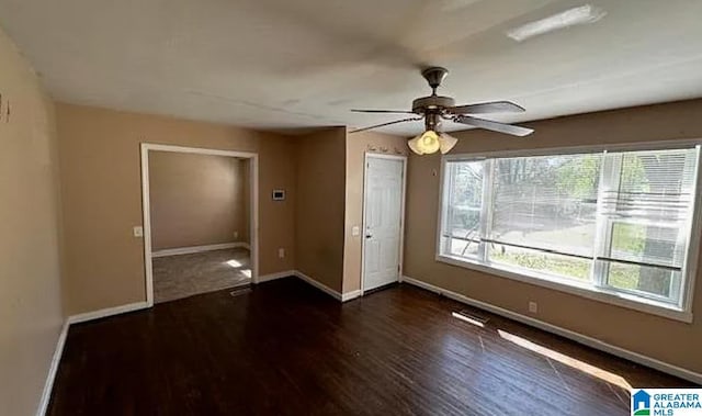 unfurnished room with ceiling fan and dark hardwood / wood-style flooring