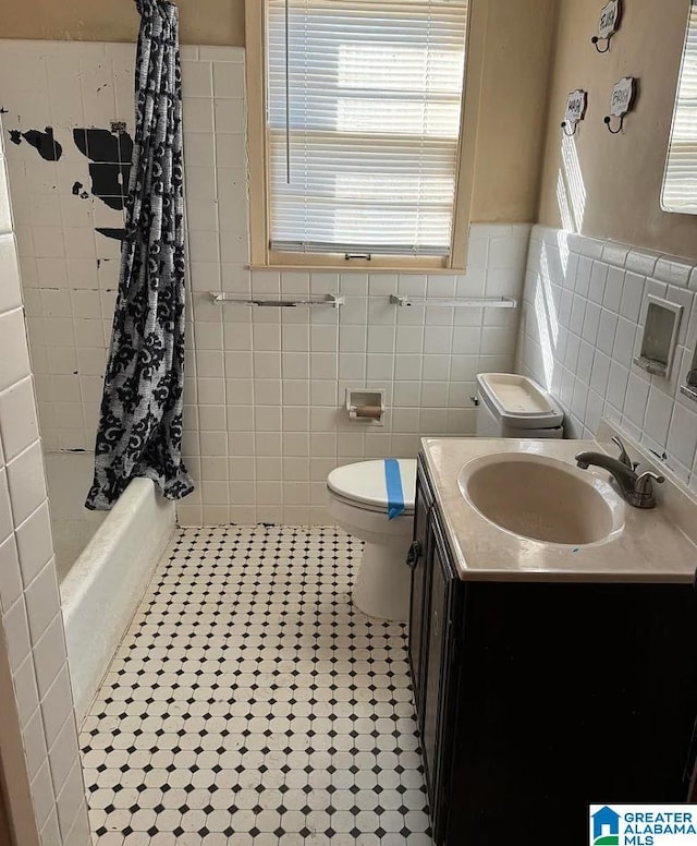 full bathroom featuring tile walls, shower / bath combination with curtain, vanity, toilet, and tile patterned floors