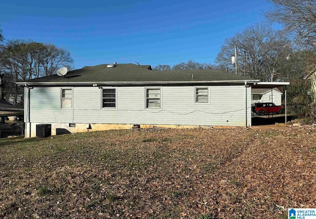 rear view of house with a carport and central AC unit