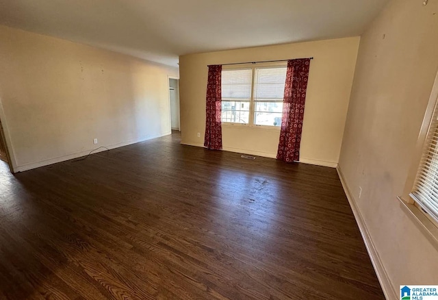 empty room with dark hardwood / wood-style flooring