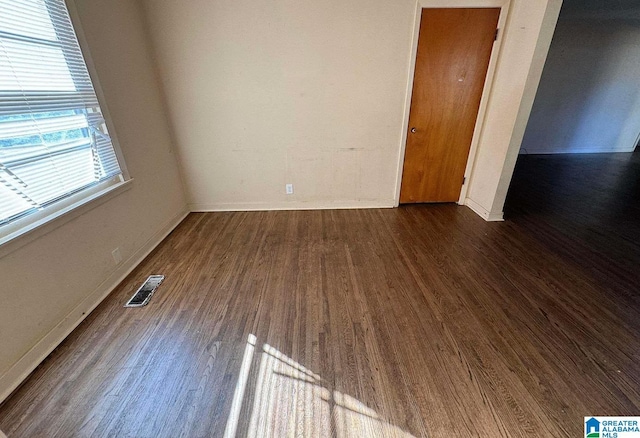 unfurnished room featuring dark wood-type flooring