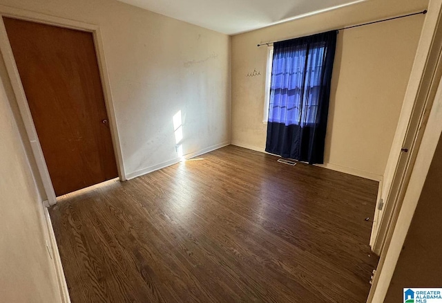 unfurnished room featuring dark hardwood / wood-style flooring